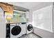 Laundry room with front load washer and dryer, overhead shelving, and ample natural light at 126 Laguna Springs Dr, Woodstock, GA 30188