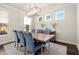 Traditional dining room with hardwood floors, modern lighting, six chairs, and three windows at 1590 Branthaven Ln, Auburn, GA 30011