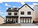 Beautiful two-story home with a modern farmhouse aesthetic, featuring a two car garage, covered entryway, and landscaped yard at 1590 Branthaven Ln, Auburn, GA 30011