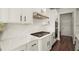 Modern kitchen with white cabinets, quartz countertops, stainless steel appliances, and hardwood floors at 1590 Branthaven Ln, Auburn, GA 30011