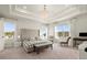 A bright main bedroom with a tray ceiling, a tufted headboard, and large windows at 1590 Branthaven Ln, Auburn, GA 30011