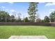 Large grassy backyard surrounded by a dark wood fence and mature trees at 203 Creek View Ln, Acworth, GA 30102