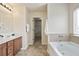 Bright bathroom featuring a tub, a window, tile flooring, and a vanity with storage at 203 Creek View Ln, Acworth, GA 30102