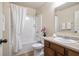 Bathroom with a shower-tub combo, a wood vanity, and a large mirror at 203 Creek View Ln, Acworth, GA 30102