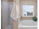Cozy bathroom featuring a tub, a shower, a window with blinds, and a plant at 203 Creek View Ln, Acworth, GA 30102
