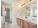 A full bathroom showcasing double sinks, brown cabinets, a mirror, and neutral paint at 203 Creek View Ln, Acworth, GA 30102
