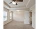 A large carpeted bedroom featuring a tray ceiling, ceiling fan, and natural light at 203 Creek View Ln, Acworth, GA 30102