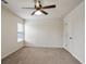 A carpeted bedroom with natural light through a window, showing a door and a ceiling fan at 203 Creek View Ln, Acworth, GA 30102