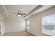 A carpeted bedroom featuring tray ceiling with fan, and natural light from two windows at 203 Creek View Ln, Acworth, GA 30102