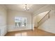 Open dining room with hardwood floors, staircase, and abundant natural light through the large window at 203 Creek View Ln, Acworth, GA 30102