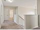 Upstairs hallway with carpet, showing view to a bathroom and stairway with iron railing at 203 Creek View Ln, Acworth, GA 30102