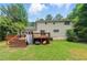 Exterior shot of backyard featuring a deck, grass, and shade trees at 4773 Aberdeen Ln, Stone Mountain, GA 30083