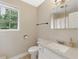 Bright bathroom featuring a white vanity, sink, toilet, and window at 4773 Aberdeen Ln, Stone Mountain, GA 30083