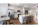 Open-concept kitchen with stainless steel appliances, island with seating, and white cabinets at 11684 Stovall Pl, Hampton, GA 30228