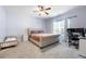 Bedroom with ceiling fan, neutral walls, plush carpeting, queen bed and large window at 11684 Stovall Place Pl, Hampton, GA 30228