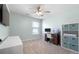 A bright bedroom with light walls, a large window and desk area with office shelving at 11684 Stovall Place Pl, Hampton, GA 30228