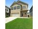 Inviting two-story brick home with lush green lawn and convenient two-car garage, ideal for families at 11684 Stovall Place Pl, Hampton, GA 30228
