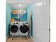 Conveniently located laundry room with washer, dryer, shelving, and tile flooring at 11684 Stovall Place Pl, Hampton, GA 30228