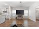 Bright living area with wood floors, large TV, and seamless connection to the modern kitchen at 11684 Stovall Place Pl, Hampton, GA 30228