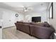 Bright living room with laminate flooring, ceiling fan, TV, and a comfortable sectional sofa at 11684 Stovall Place Pl, Hampton, GA 30228