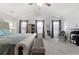 This is a carpeted main bedroom featuring tray ceilings and multiple sunny windows at 11684 Stovall Place Pl, Hampton, GA 30228