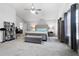 This main bedroom features soft carpet, neutral walls and a gray, tufted king bed at 11684 Stovall Place Pl, Hampton, GA 30228
