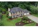 Aerial view showcasing a well-landscaped brick home with a manicured lawn and an attached three-car garage at 1338 Nonie Way, Marietta, GA 30062