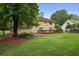 Expansive backyard featuring a lush lawn, mature trees, and a wood deck, creating a serene outdoor space at 1338 Nonie Way, Marietta, GA 30062
