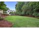 Lush backyard showcasing a well-manicured lawn, bordered by trees and a wooden deck, offering privacy at 1338 Nonie Way, Marietta, GA 30062