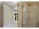 Bathroom featuring a glass-enclosed shower, tub, and bright outdoor views at 1338 Nonie Way, Marietta, GA 30062