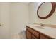 Bathroom showcasing a classic vanity, toilet, and a round wood-framed mirror at 1338 Nonie Way, Marietta, GA 30062