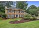 Charming two-story brick home with a manicured lawn and lush landscaping at 1338 Nonie Way, Marietta, GA 30062
