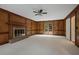 Spacious carpeted living room with wood paneled walls and cozy brick fireplace at 1338 Nonie Way, Marietta, GA 30062