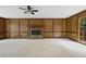 Spacious carpeted living room with wood paneled walls and cozy brick fireplace at 1338 Nonie Way, Marietta, GA 30062