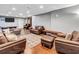 Open basement space with several sofas and wooden bench with recessed lighting and TV at 155 Matthew Way, Fayetteville, GA 30214