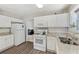 Bright eat-in kitchen featuring white cabinetry, granite countertops, stainless steel appliances, and hardwood floors at 3015 Cranbrook Nw Walk, Kennesaw, GA 30144