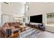 Bright living room featuring a tall ceiling, large windows, a brown leather sectional sofa, and modern decor at 3015 Cranbrook Nw Walk, Kennesaw, GA 30144