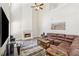 Spacious living room with a fireplace, ceiling fan, and plush brown sectional sofa at 3015 Cranbrook Nw Walk, Kennesaw, GA 30144