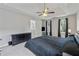Comfortable primary bedroom featuring a tray ceiling, ceiling fan, and a view to the backyard through the large window at 3015 Cranbrook Nw Walk, Kennesaw, GA 30144