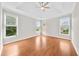 Spacious bedroom with hardwood floors, a ceiling fan, and windows that let in plenty of natural light at 307 Cabinwood Trl, Canton, GA 30115