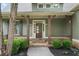 Covered front porch with wooden support beams, a stone pathway, and lush landscaping creates a welcoming entrance at 307 Cabinwood Trl, Canton, GA 30115