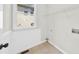 A bright laundry room space with tile floors, a window, and a wire shelf at 307 Cabinwood Trl, Canton, GA 30115