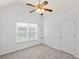 This bedroom is bright with natural light from the window, plush carpet, and a ceiling fan at 3242 Monarch Pine Dr, Peachtree Corners, GA 30071