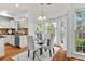 Bright breakfast nook with large windows, glass table, four chairs, and modern chandelier at 3242 Monarch Pine Dr, Peachtree Corners, GA 30071