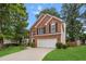 Attractive brick home showcases manicured lawn, mature trees, and a two-car garage at 3242 Monarch Pine Dr, Peachtree Corners, GA 30071