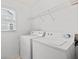 Functional laundry room with washer, dryer, storage shelf, and natural light from a window at 3242 Monarch Pine Dr, Peachtree Corners, GA 30071