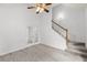 Spacious, carpeted living room with a staircase, French doors, and neutral colors at 3242 Monarch Pine Dr, Peachtree Corners, GA 30071