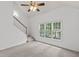Spacious living room with large windows, staircase, neutral colors, and plush carpet at 3242 Monarch Pine Dr, Peachtree Corners, GA 30071