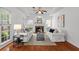 Cozy living room with fireplace, hardwood floors, tray ceilings, and large windows at 3242 Monarch Pine Dr, Peachtree Corners, GA 30071