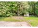 Spacious backyard features grass area and shed in wooded area at 4447 Ben Hill Rd, Lithia Springs, GA 30122